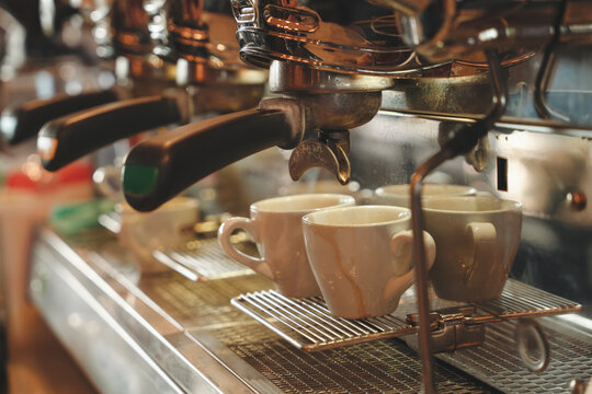 Artisan espresso machine extracts rich coffee shots in bustling cafe during morning rush hour