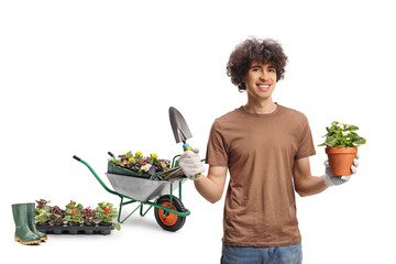 Male gardener with a wheelbarrow holding a flower pot and a spade