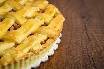 Delicious round apple pie resting on wooden table
