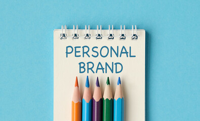 A notebook with a pencils on it and the word Personal Brand written on it
