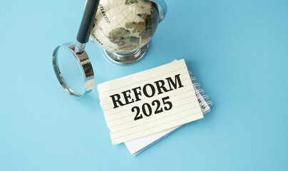 A globe sits on a table next to a piece of paper that says Reform 2025