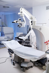Empty operating room featuring advanced surgical microscope and covered operating table, showcasing modern medical equipment and technology prepared for surgical procedure
