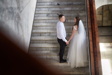 Couple exchanging vows on a grand staircase during their wedding registration ceremony at a...