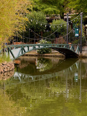 Naklejka premium Chained Pedestrian Bridge with Reflections over Tranquil Pond