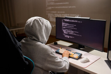 A young programmer codes intently in a dark setting, immersed in his work and creativity