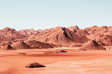 Red desert mountains under clear sky, arid alien-like landscape

