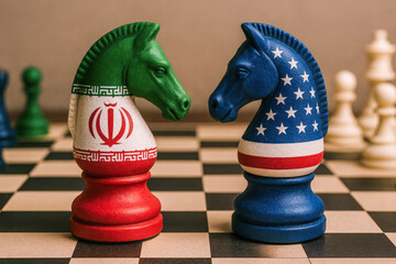 Symbolic chess pieces painted with Iranian and American flags facing off on a chessboard, illustrating strategic geopolitical rivalry.