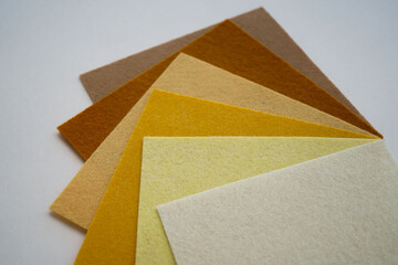 Different shades of beige felt folded vertically on top of each other. From dark blue to light pink.