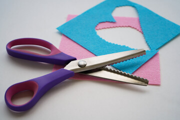 The scissors are on the felt fragments. Crafting and sewing work.