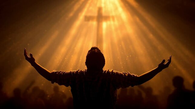 backlit image of a believer hands to heaven worshiping the cross	
