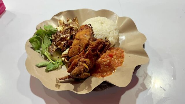 Pecel Ayam &mdash; Indonesian-style fried chicken served with sambal, steamed rice, and fresh vegetables, a flavorful and affordable street food favorite. June 1, 2025 - Tanah Abang, Indonesia.