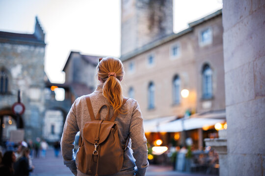 Fototapeta Solo traveler exploring Bergamo streets at sunset during vacation in Italy. Evening at Piazza Vecchia city square in Citta Alta, Bergamo, Italy