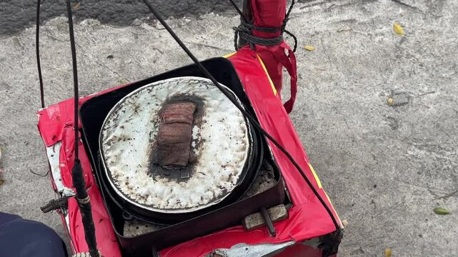 Street vendor preparing kue cubit &mdash; a popular Indonesian mini pancake snack cooked fresh on the roadside, loved for its soft texture and nostalgic flavor. Karet, Indonesia - June 25, 2025