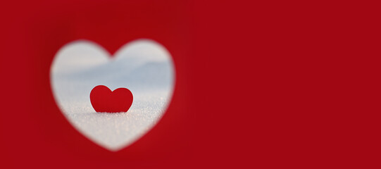 Happy Valentine's Day celebration. The concept of love in the form of a heart. Postcard dated February 14th, red heart in the snow, a place for the text. Winter holidays. Paper red heart.