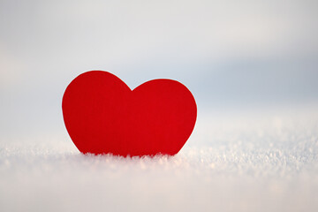 Happy Valentine's Day celebration. The concept of love in the form of a heart. Postcard dated February 14th, red heart in the snow, a place for the text. Winter holidays. Paper red heart