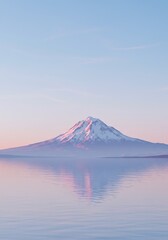 Fototapeta premium Majestic Snow-Capped Mountain Reflects Serene Water Under Pale Blue Sky
