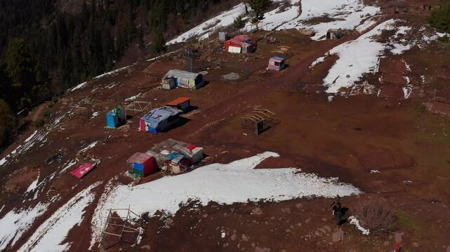 Drone view of melted snow from the top of the mountains with small tent houses in  Siri Paye