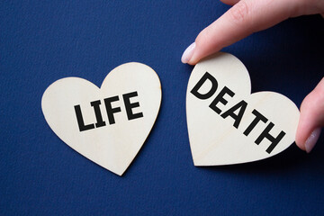 Life or Death symbol. Concept word Life or Death on wooden hearts. Businessman hand. Beautiful deep...