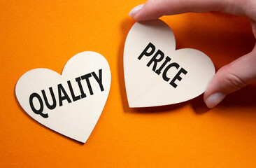 Price or Quality symbol. Concept word Price or Quality on wooden hearts. Businessman hand....