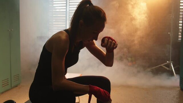 Women self defense girl power. Strong athlete woman fighter remove boxing gloves after fight training on boxing ring. Strong girl tired after training session in gym. Strength fit body workout