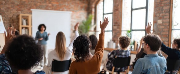 The engaged audience raises hands during an interactive workshop session.