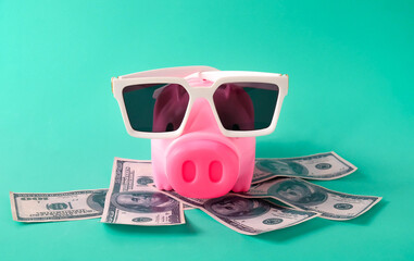 piggy bank with sun glasses over US bank note ,Vocation concept.