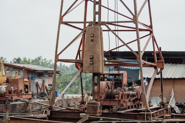 An old drilling rig situated in a construction site, showcasing heavy machinery and industrial...