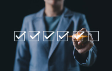 Checklist for Task Completion and Planning. A person checkmarks on checklist, representing...