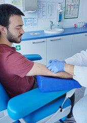 Closeup Hands of nurse, doctor or Medical technologist in blue gloves taking blood sample from...