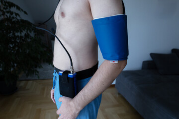 young man with a daily blood pressure measuring device at home. Healthcare. Medical checkup in at a...