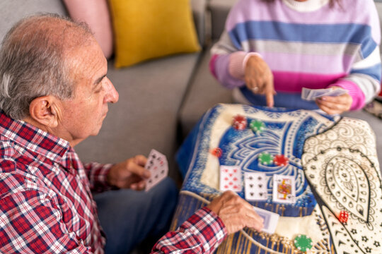 Senior couple playing cards and enjoying retirement at home