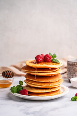 Healthy summer breakfast, homemade classic american pancakes with fresh berries and honey. High...
