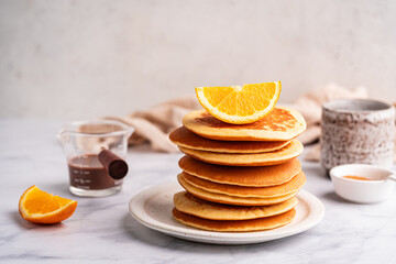 Healthy summer breakfast, homemade classic american pancakes with fresh orange and honey. High quality photo