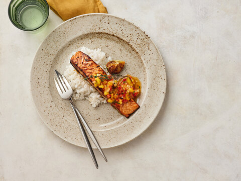 Delicious Grilled Salmon Served With Rice and Fresh Salsa on a Ceramic Plate