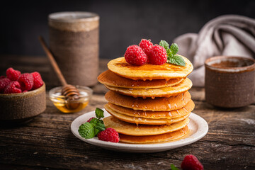 Healthy summer breakfast, homemade classic american pancakes with fresh berries and honey. High quality photo
