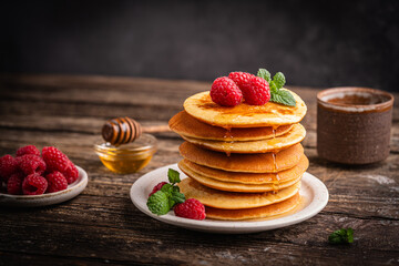 Healthy summer breakfast, homemade classic american pancakes with fresh berries and honey. High quality photo