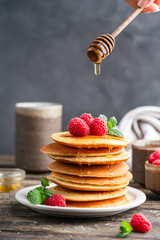 Healthy summer breakfast, homemade classic american pancakes with fresh berries and honey. High quality photo