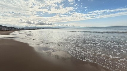 A walk along the sandy beach near the calm sea. High quality 4k footage