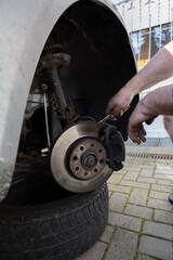 close up of man´s hands reparing the car. worker on the street lifting his car with the jack....