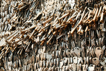 Close-up of a large collection of old metal keys tied together with wire. A textured background...