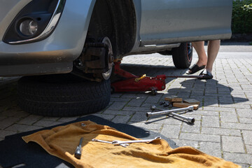 close up of man´s hands reparing the car. worker on the street lifting his car with the jack....