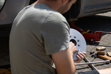 close up of man´s hands reparing the car. worker on the street lifting his car with the jack....