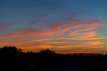 Beautiful orange sunset with clouds and silhouette. 