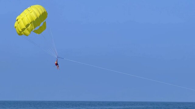 Parasailing in the sea. A popular tourist pastime with a parasailing parachute attached to a motorboat. 