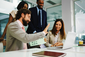Naklejka premium Business team analyzing data on laptop in modern office