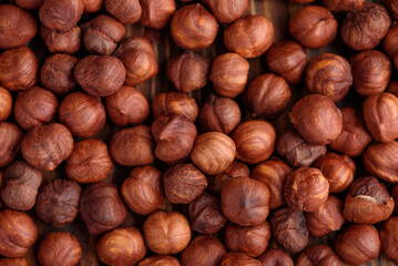 Close-up of roasted hazelnuts on a wooden surface. Top view