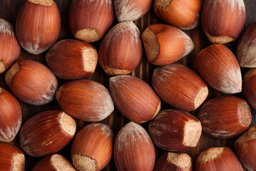Whole hazelnuts in their shells scattered on a wooden background. Top view