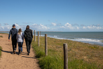 family people walking along the wild coast in pathway vendee France