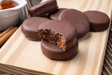 Brazilian Pao de Mel or chocolate covered honey cookies over a wooden table