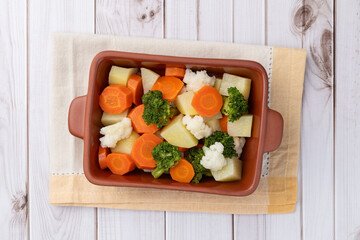 Cooked vegetables in a plate over wooden table
